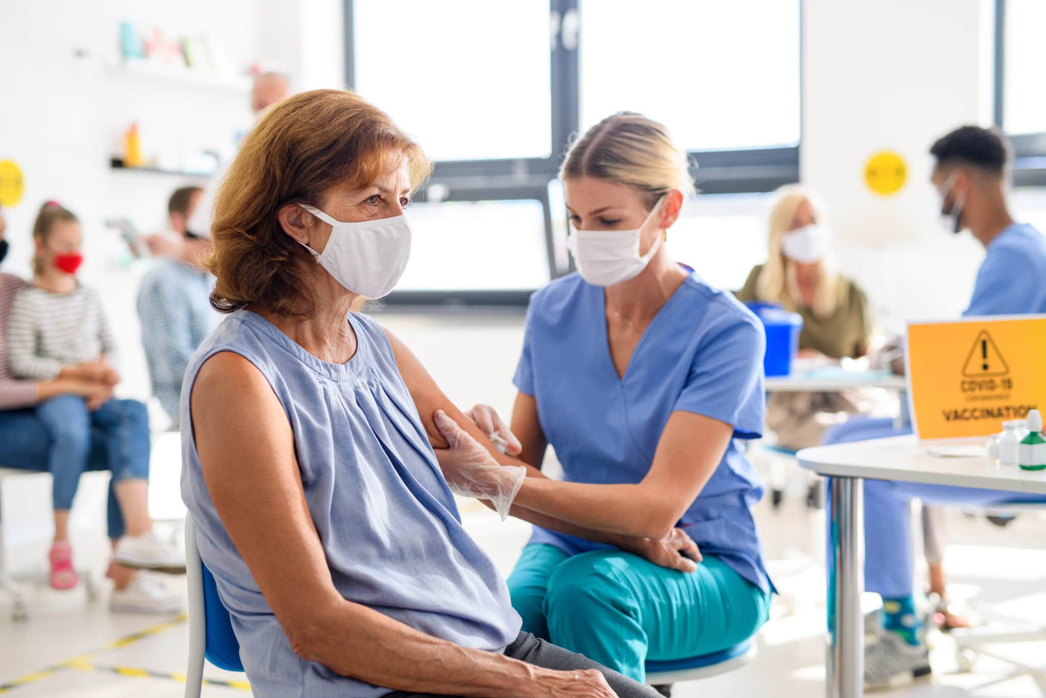 Woman receives a vaccine from a healthcare worker