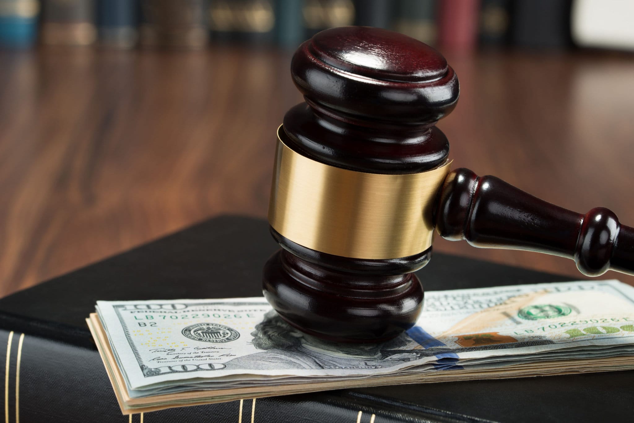 gavel resting on top of stack of money to show law prosecuting anticorruption