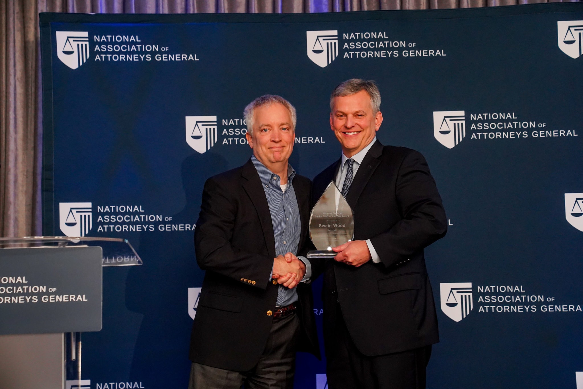 North Carolina Attorney General Josh Stein hands senior staff award to Swain Wood. North Carolina Attorney General Josh Stein presents 2022 Senior Staff Award to Swain Wood.