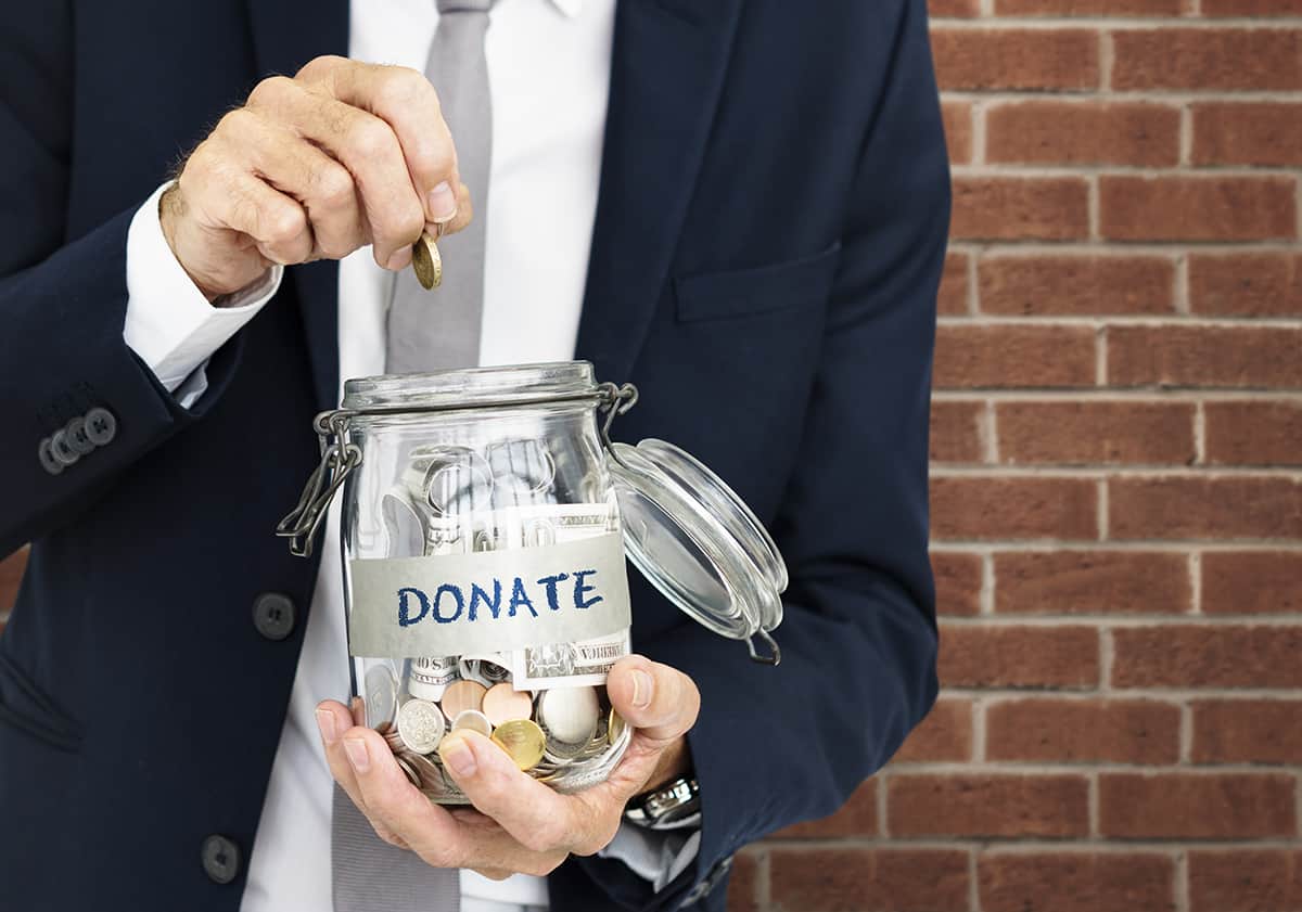 Person putting money into donation jar