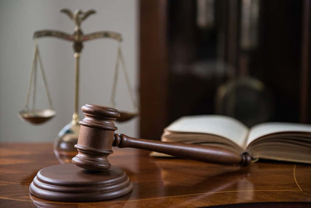 Judge's desk with legal book, scales of justice, and a gavel